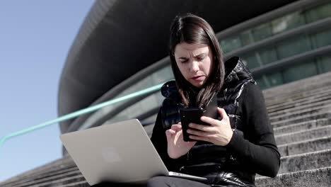 Mujer-Seria-Usando-Computadora-Portátil-Y-Teléfono-Inteligente